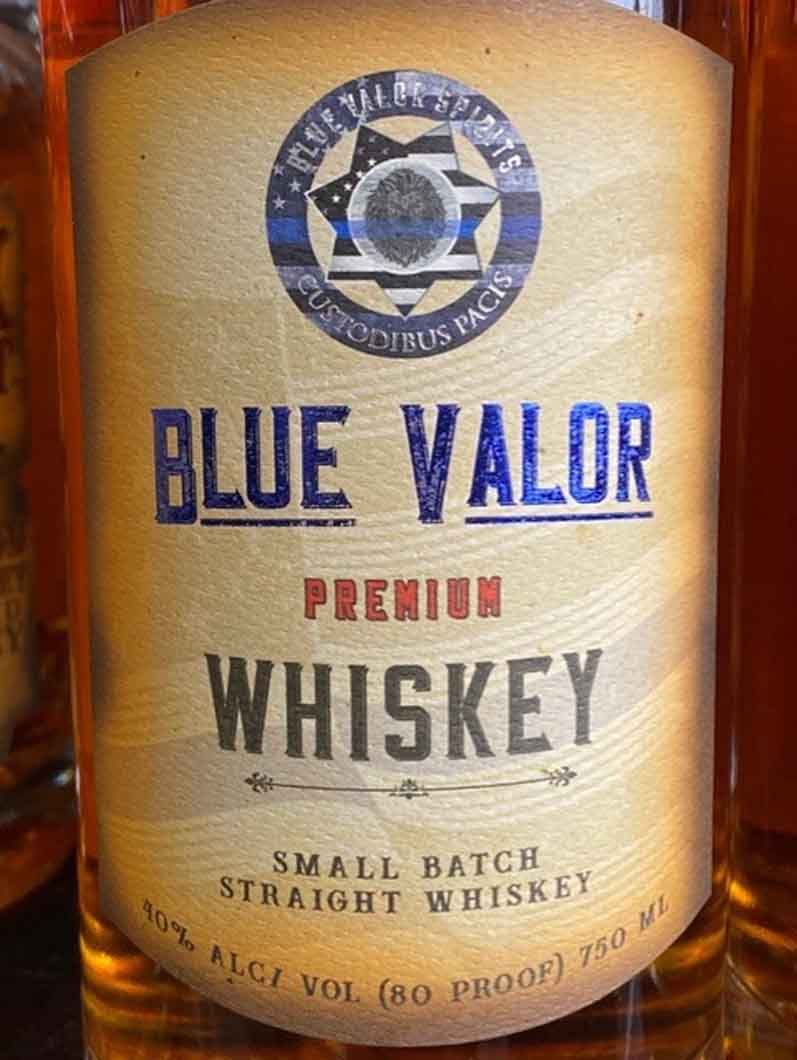 A bottle of blue valor premium whiskey is sitting on a table.