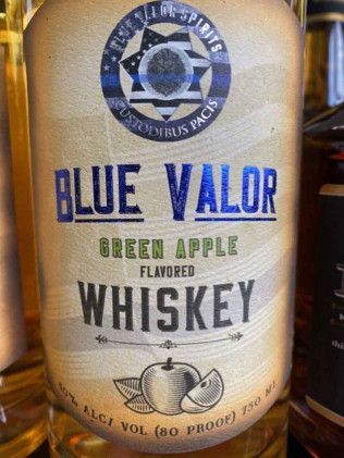 A bottle of blue valor green apple flavored whiskey