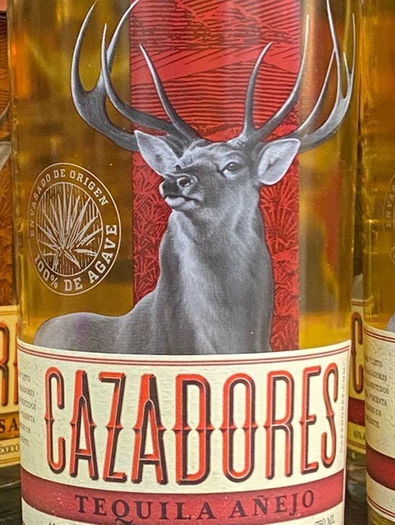 A bottle of cazadores tequila añejo with a deer on the label