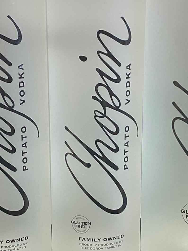 Three bottles of chopin potato vodka are lined up on a table.