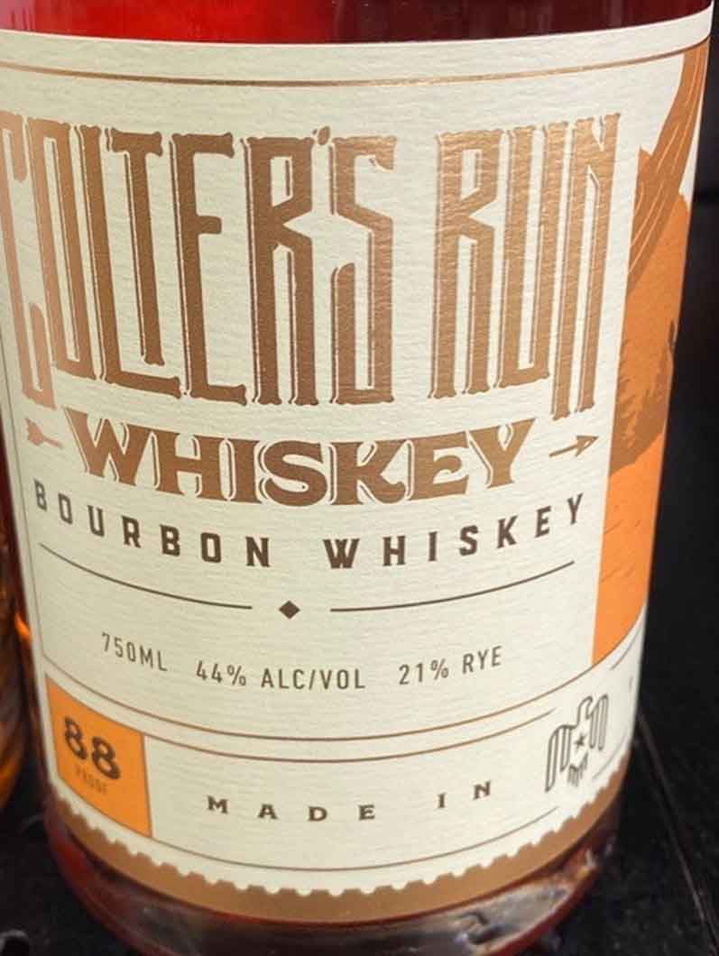 A bottle of waters run bourbon whiskey is sitting on a table