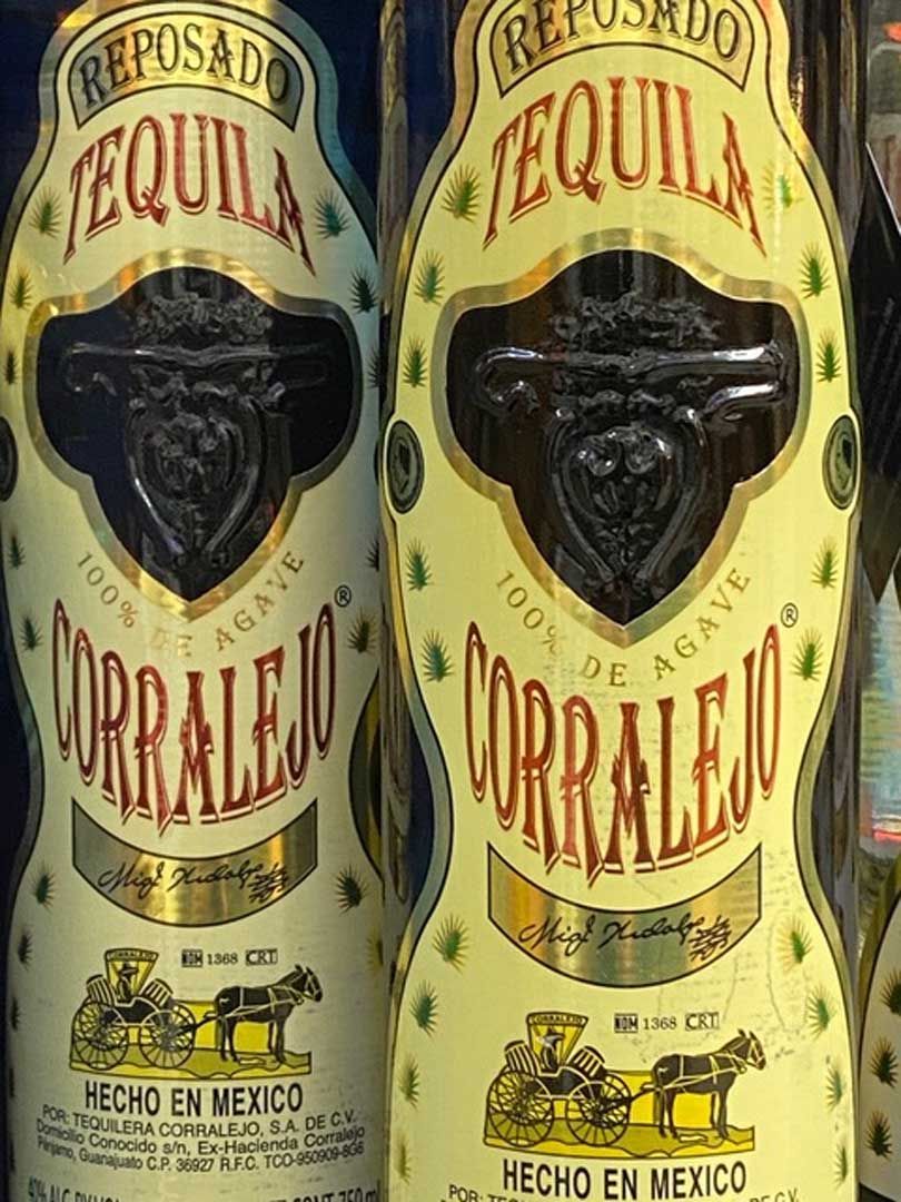 Two bottles of tequila are sitting next to each other on a table.