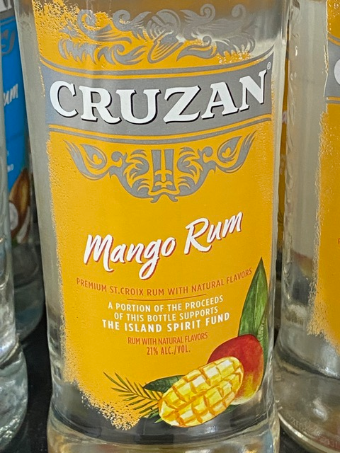 A bottle of cruzan mango rum is sitting on a table.