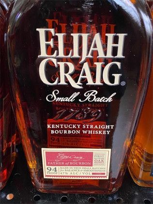 A bottle of elijah craig small batch kentucky straight bourbon whiskey is on a shelf.