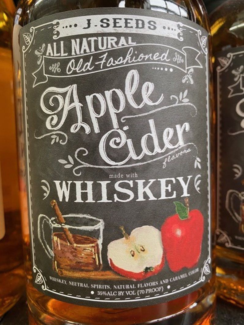 A bottle of apple cider whiskey is sitting on a table.