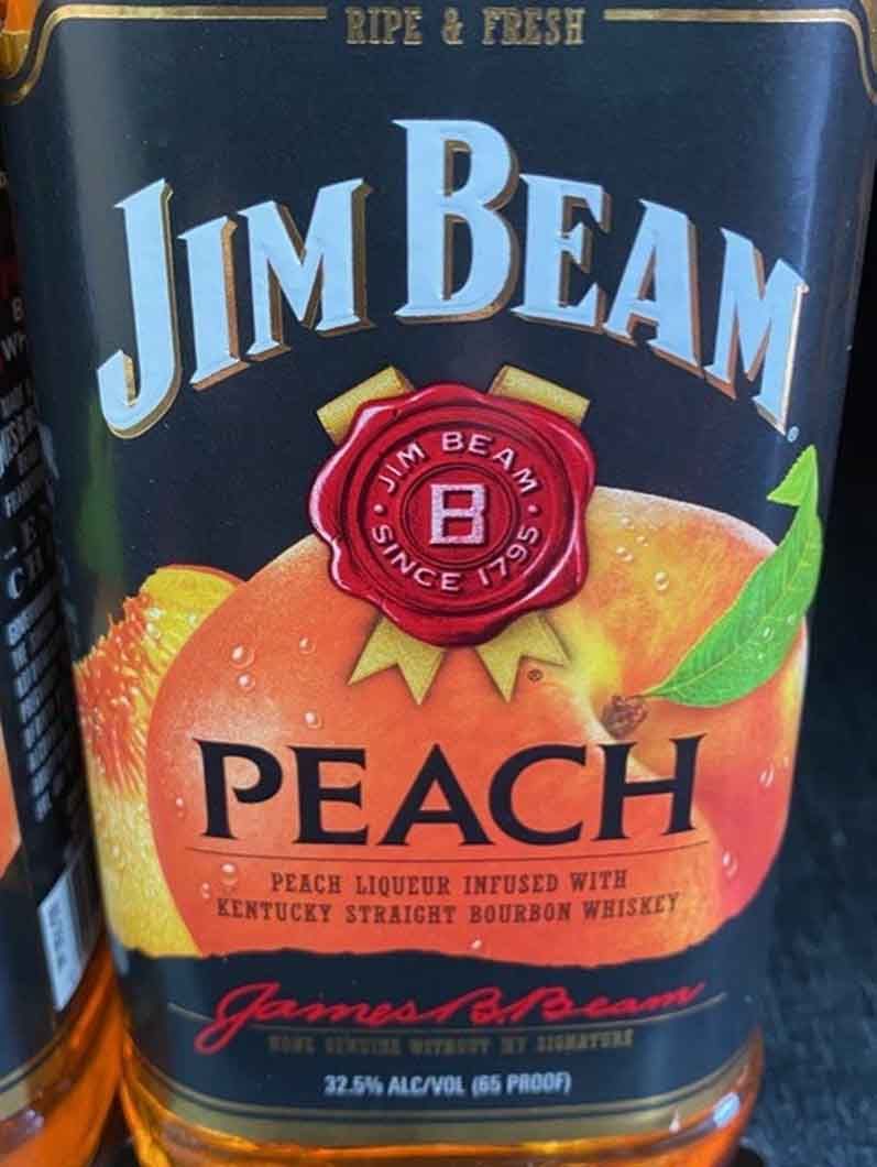 A bottle of jim beam peach sits on a table