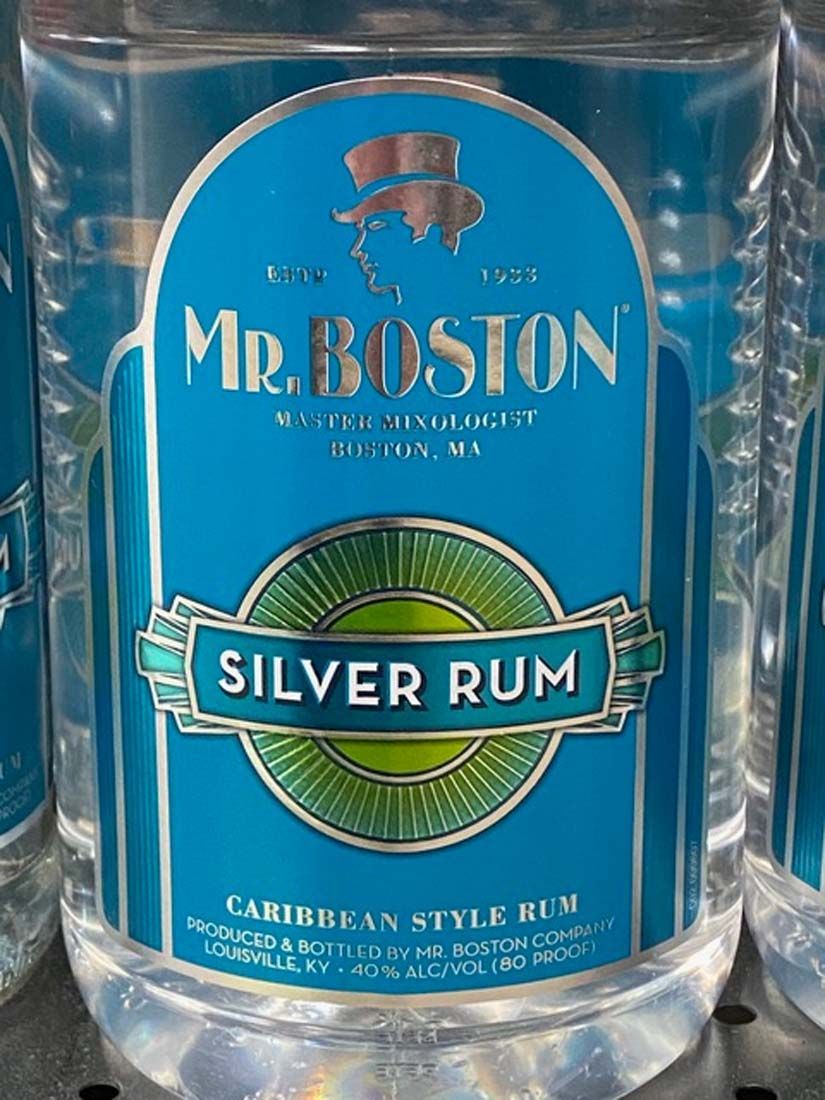 A bottle of mr. boston silver rum is sitting on a shelf