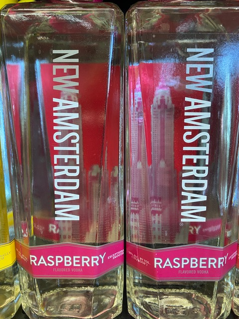 Two bottles of new amsterdam raspberry vodka on a shelf