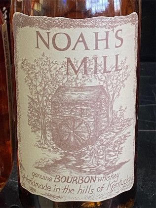 A bottle of noah 's mill bourbon whiskey is sitting on a table.