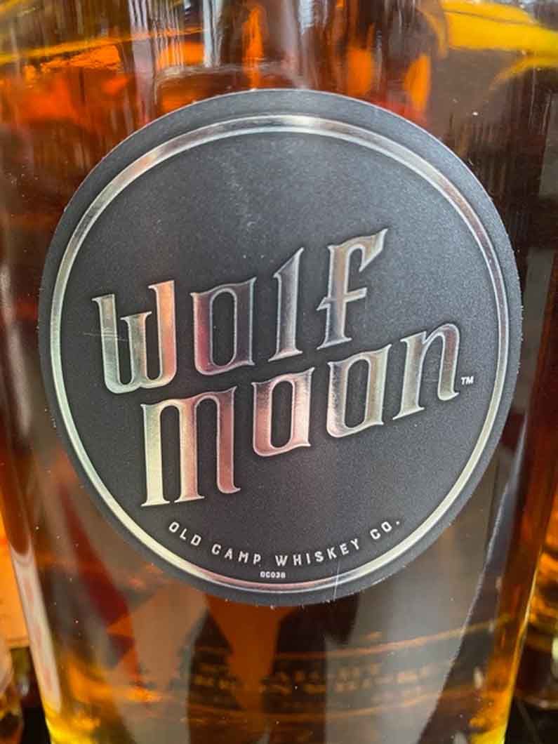 A bottle of wolf moon whiskey is sitting on a table.