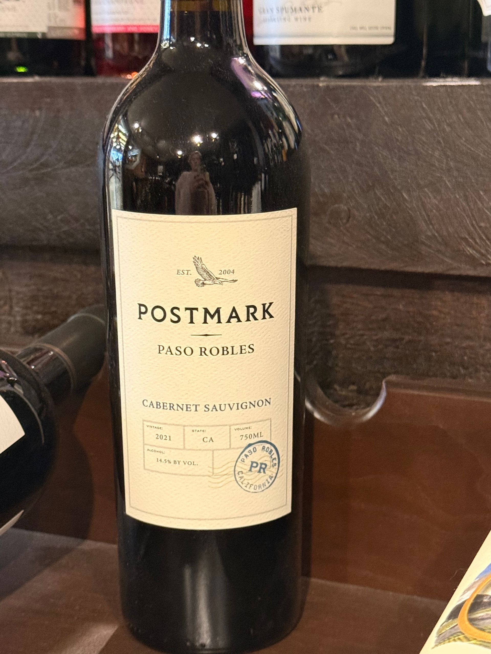 Francis Coppola Pinot Noir wine bottle with a blue label and a sign that reads