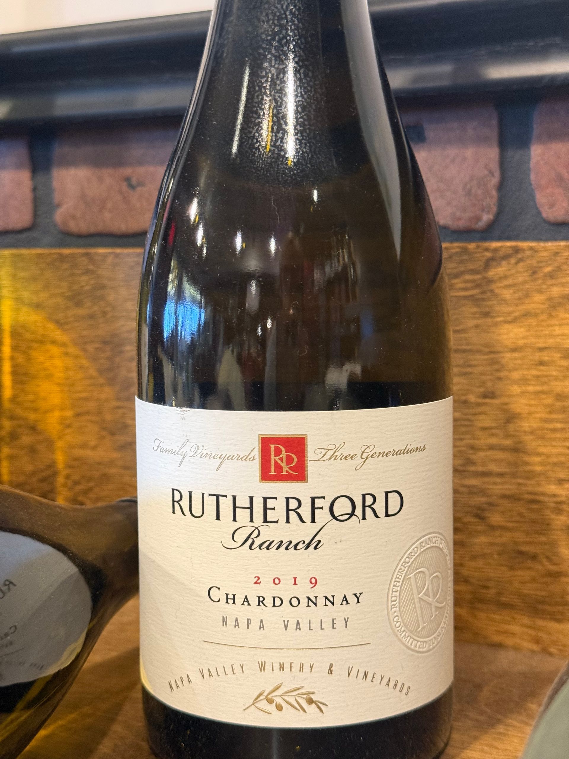 Bottle of Rutherford Ranch 2013 Chardonnay, Napa Valley. Beige label with red logo and text on a dark brown bottle.