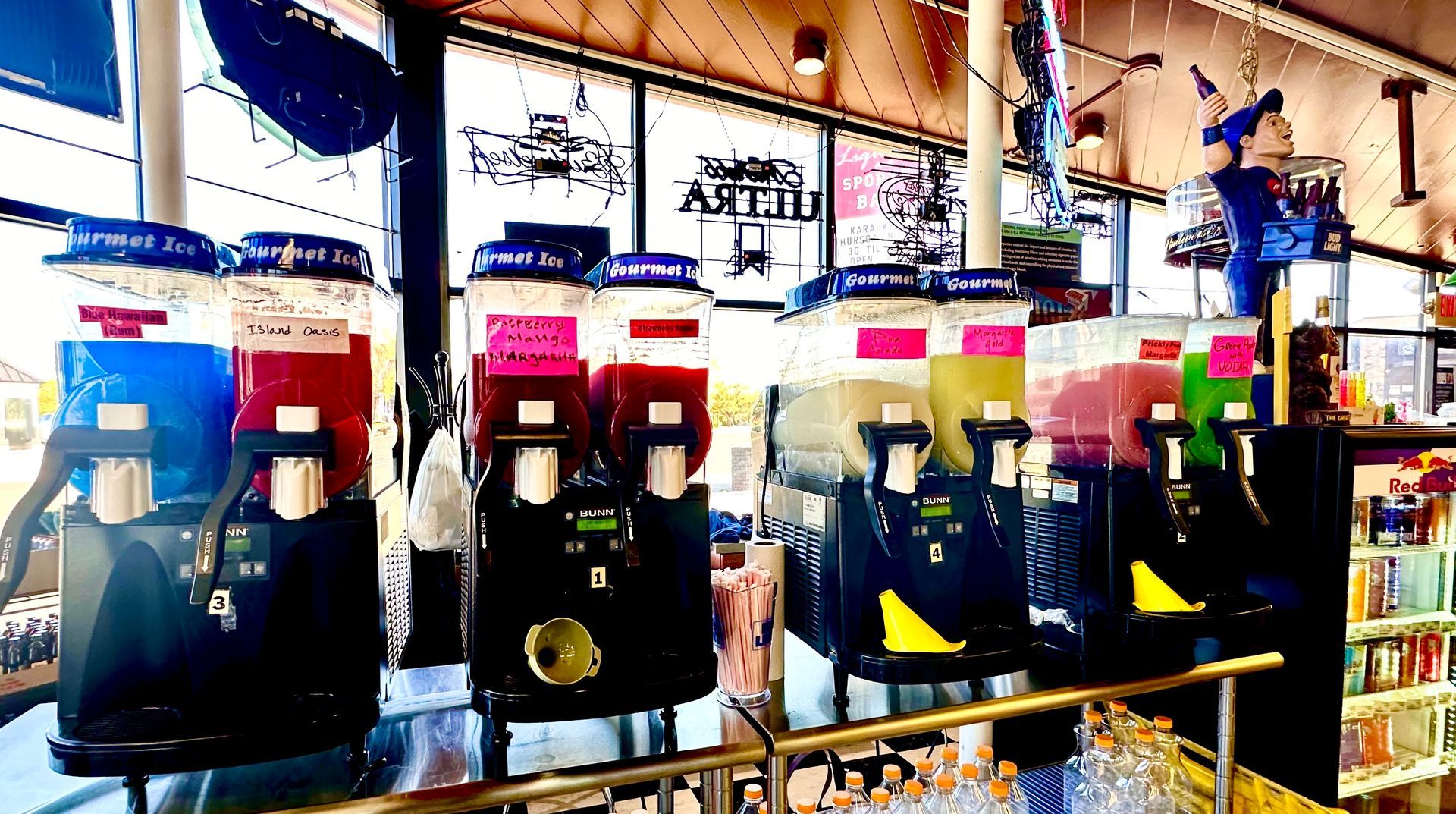 A row of drink dispensers are lined up in a store.