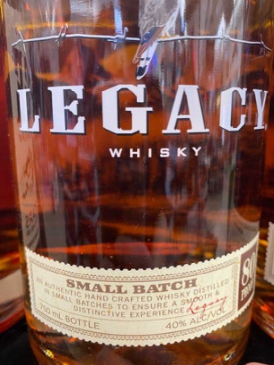 A bottle of legacy whisky sits on a table