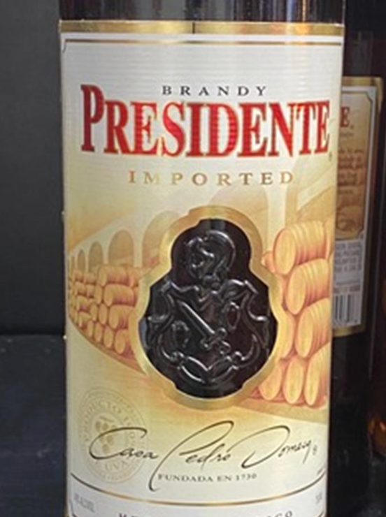 A bottle of presidente brandy is sitting on a table