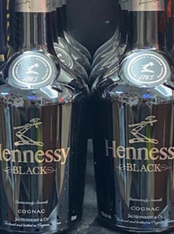 Two bottles of hennessy black cognac are sitting next to each other