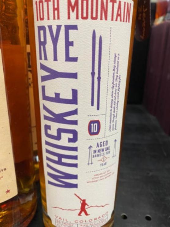 A bottle of 10th mountain whiskey sits on a table