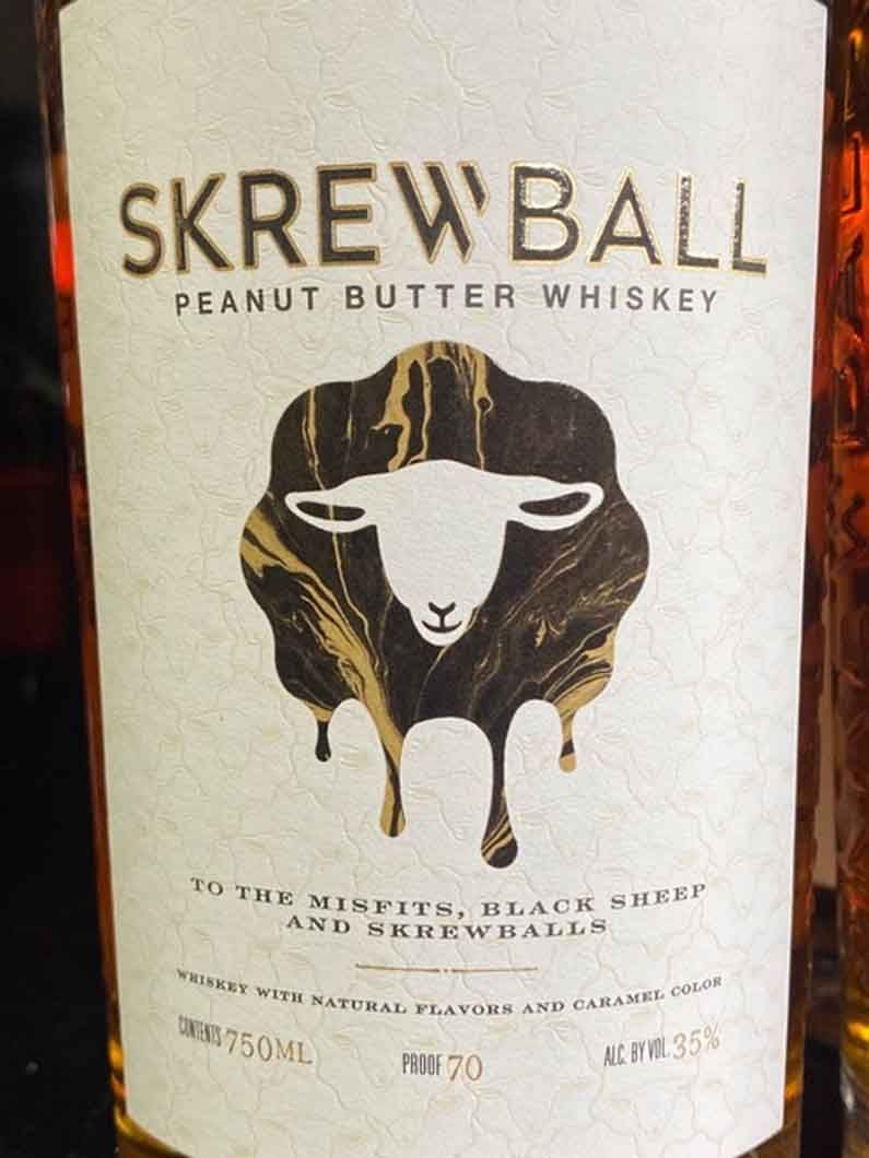 A bottle of skrew ball peanut butter whiskey with a sheep on the label