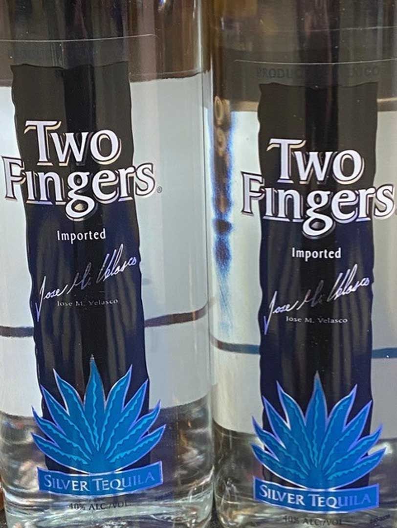 Two bottles of two fingers silver tequila are sitting next to each other.