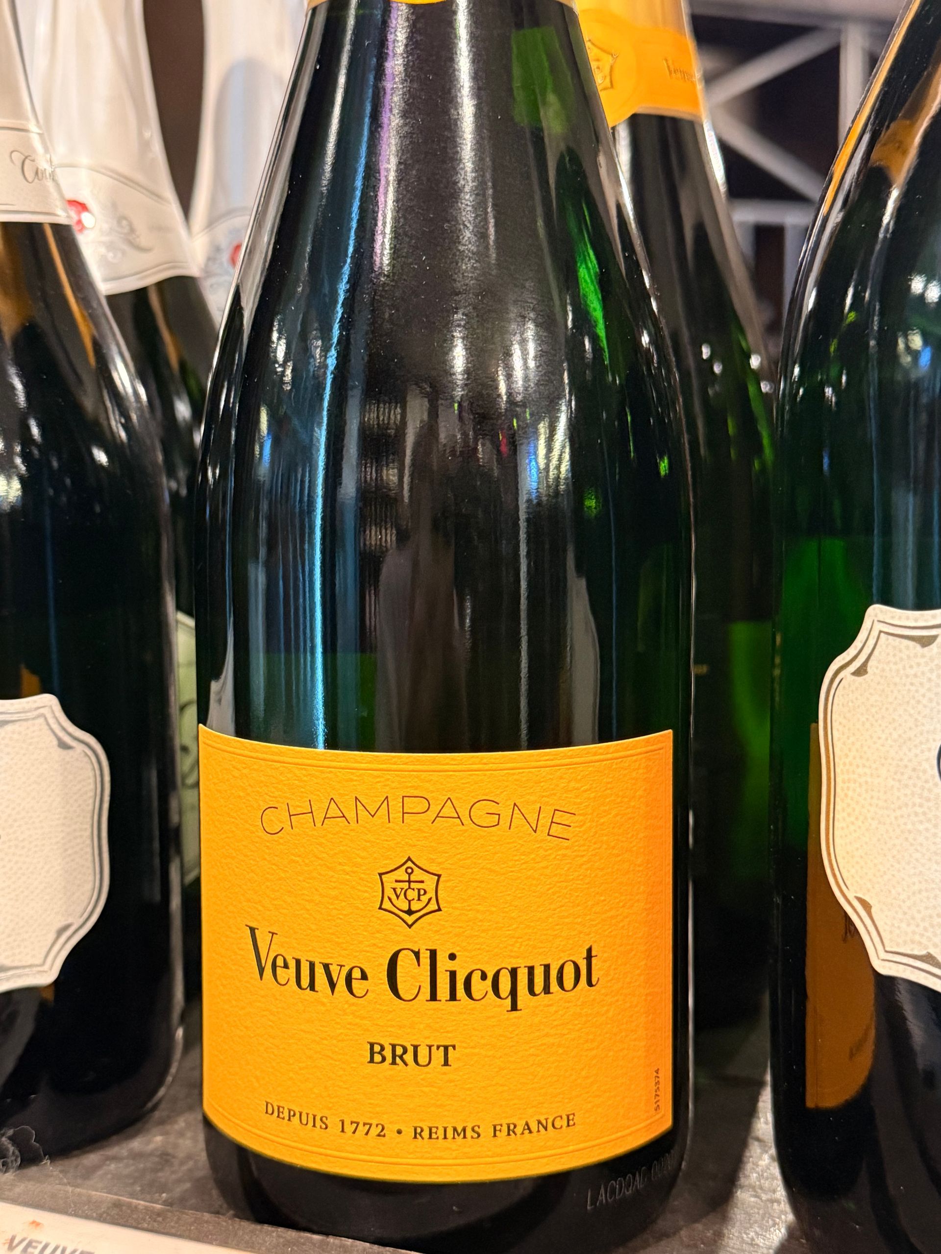 Bottle of Oyster Bay Sauvignon Blanc wine. White label with blue and gold accents, against a wooden rack.