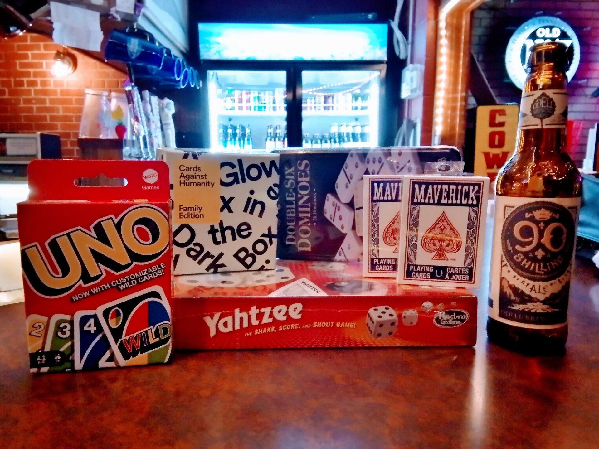 A bottle of 90 cents beer sits next to a box of uno cards