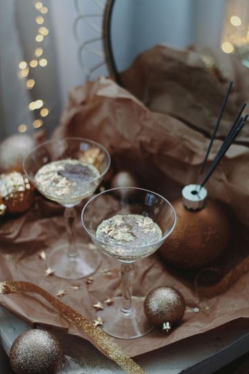 There are three glasses of champagne on a table with christmas decorations.