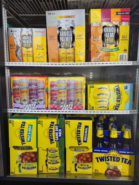 A refrigerator stocked with various alcoholic beverages, including Twisted Tea and Arnold Palmer Spiked.