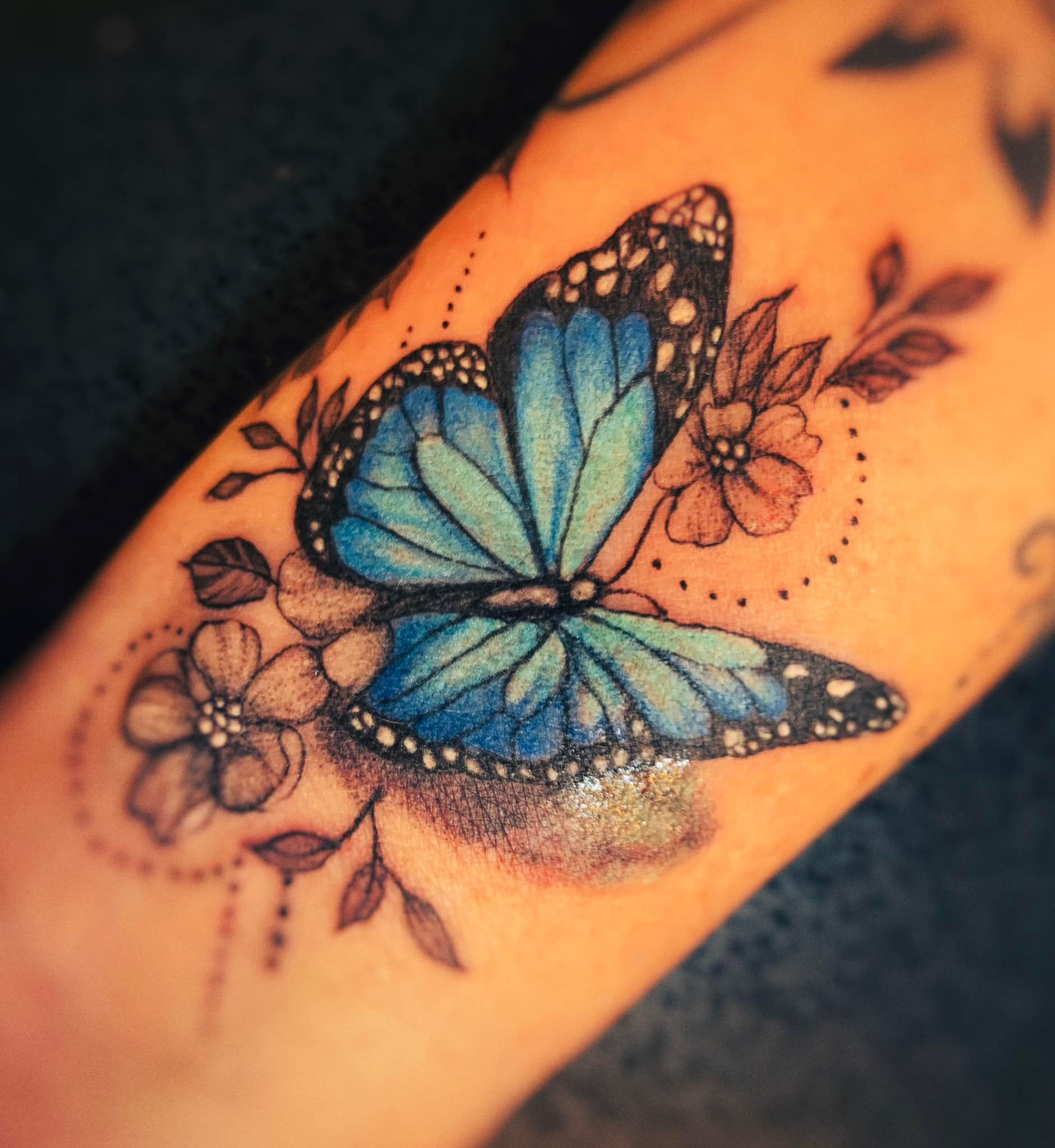 A Woman Has a Blue Butterfly Tattoo on Her Arm — Thaiger Ink in Holloways Beach, QLD