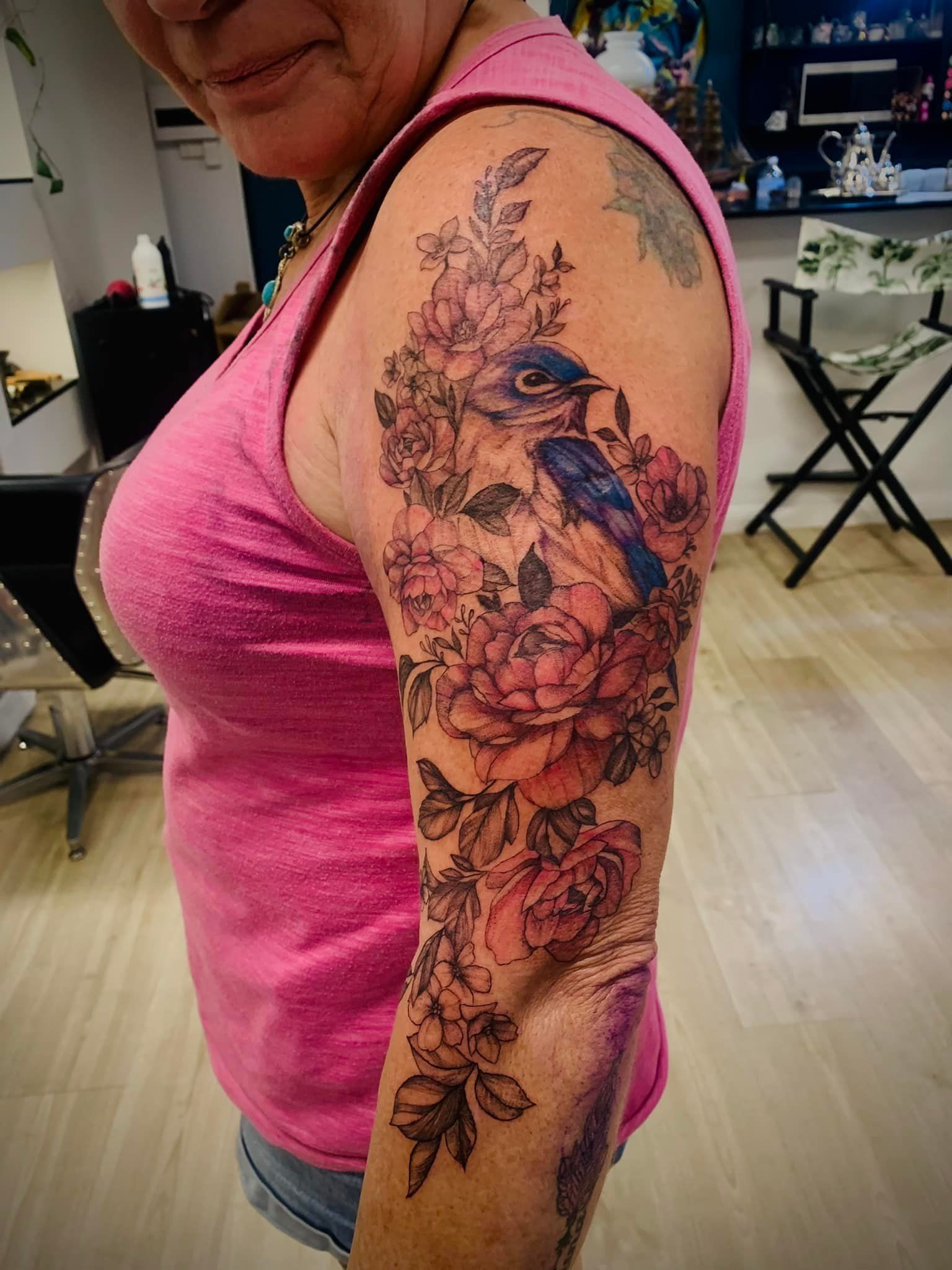 Woman's Arm Tattoo of A Blue Bird Amidst Pink Roses and Foliage — Thaiger Ink In Holloways Beach, QLD