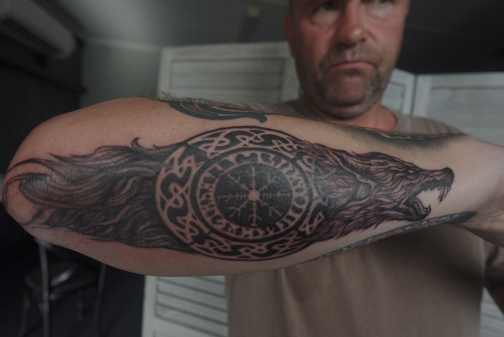Man with Forearm Tattoo of A Wolf and A Circular Viking Symbol — Thaiger Ink In Holloways Beach, QLD