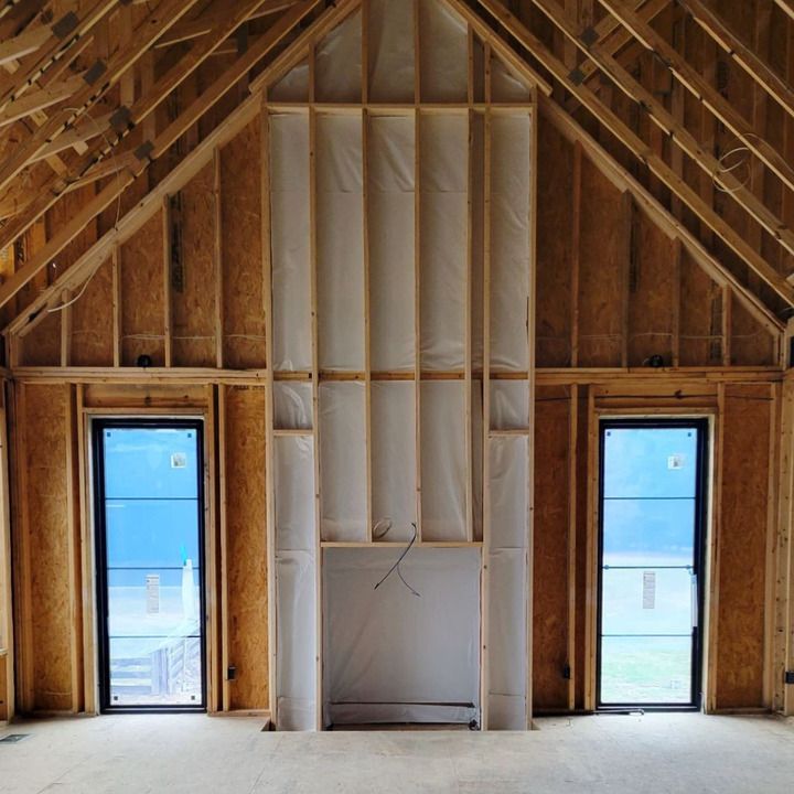 A room with a fireplace and two windows in it