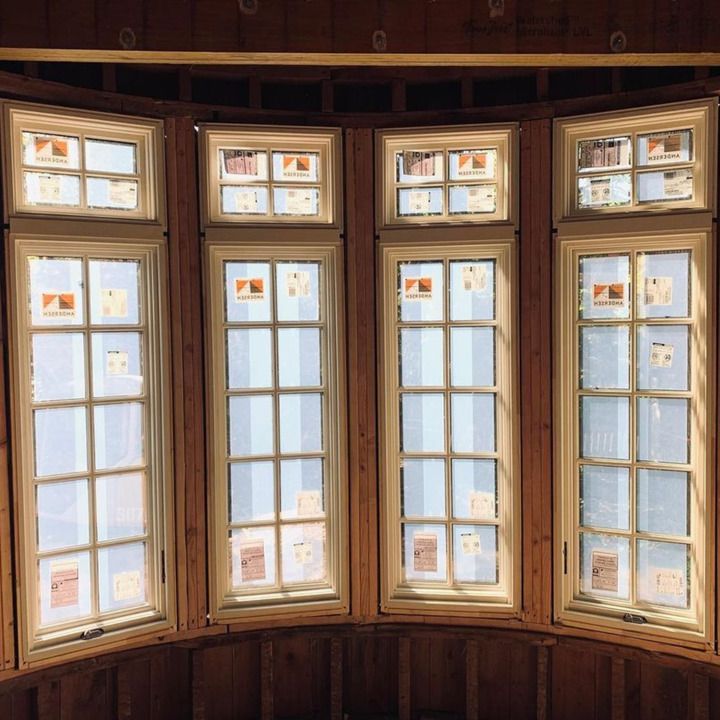 A room with a lot of windows and a wooden wall.