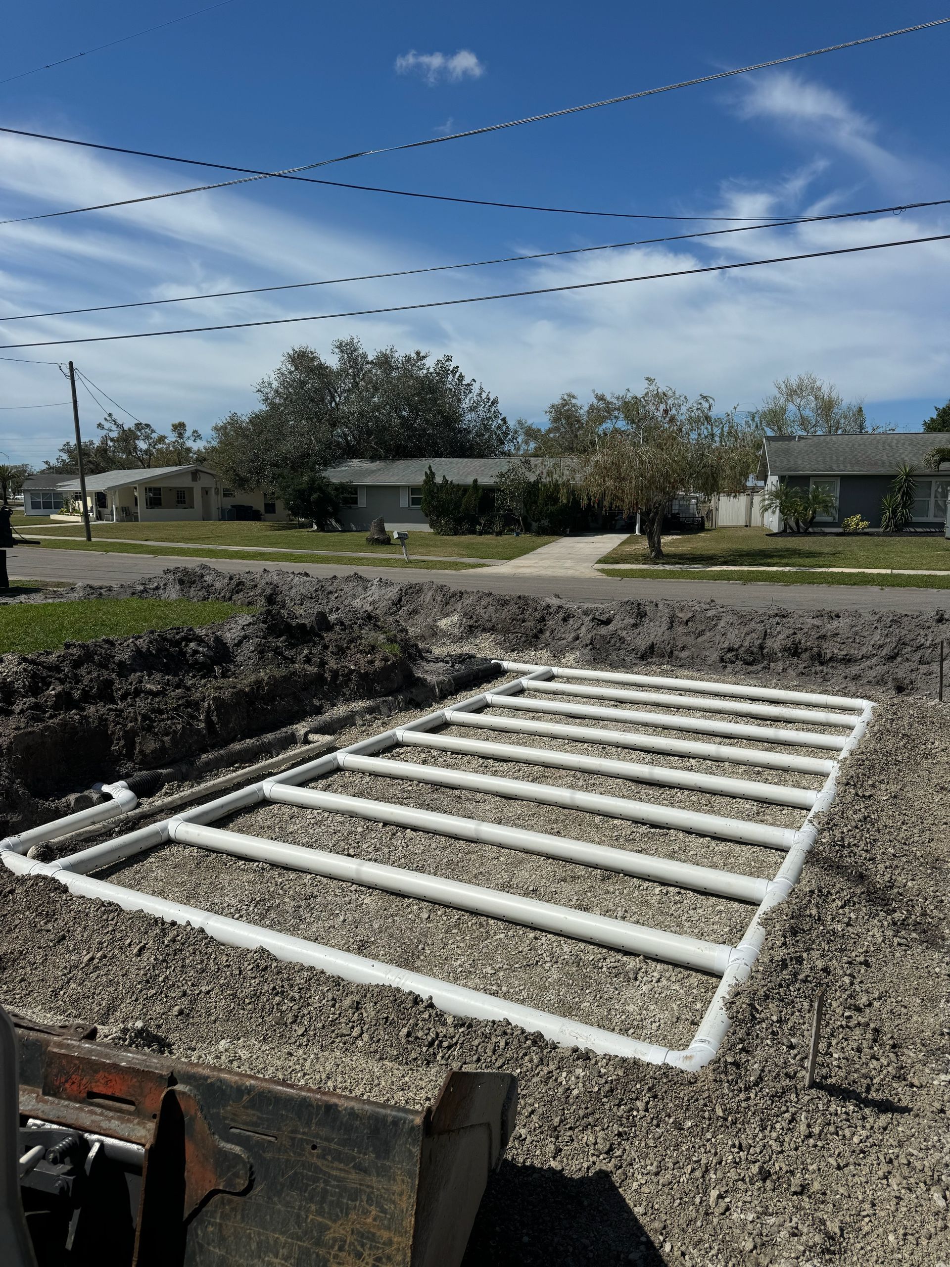 A dump truck is parked in a parking lot next to a trailer.
