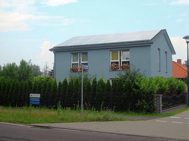 Ein Haus mit vielen Fenstern und einem Schild davor.