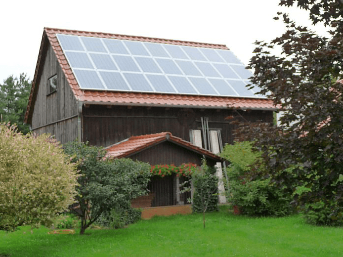 Ein Haus mit vielen Sonnenkollektoren auf dem Dach