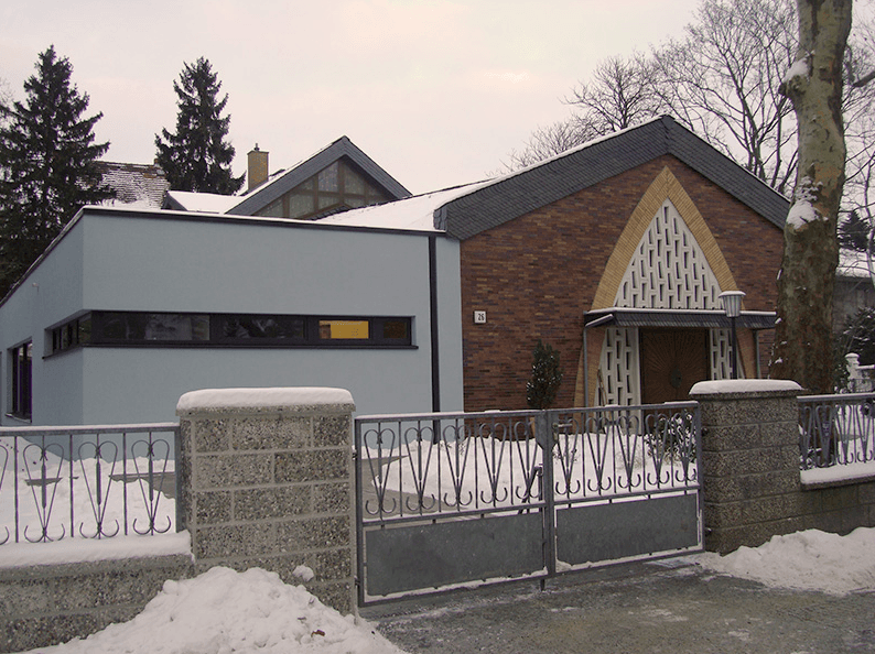 Ein Backsteingebäude mit einem Zaun davor