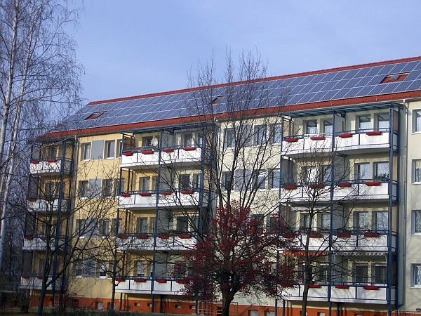 Ein großes Mehrfamilienhaus mit Sonnenkollektoren auf dem Dach