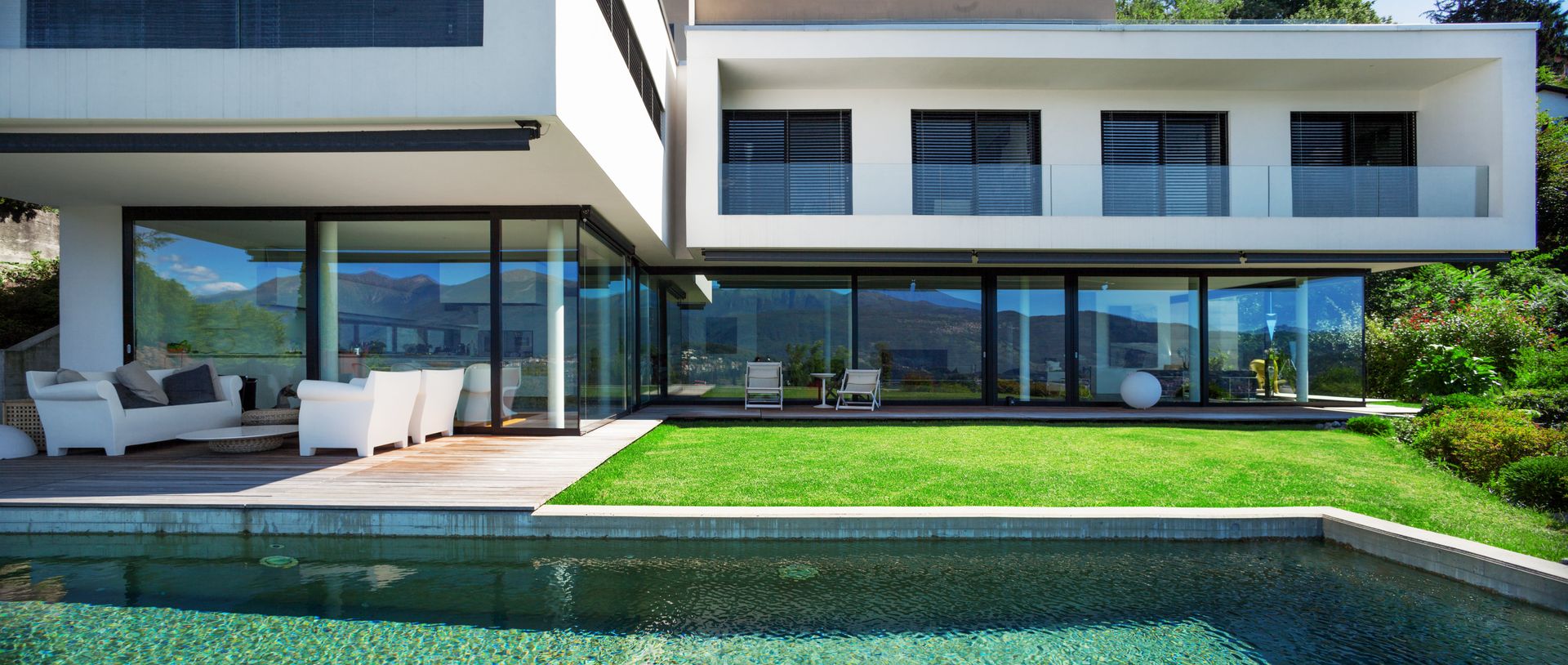 Ein modernes Haus mit einem Swimmingpool davor.