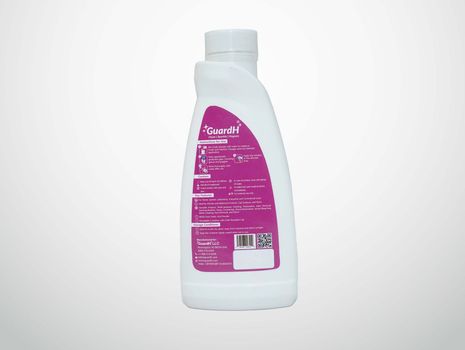 A white bottle with a purple label is on a white background.