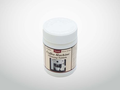 A bottle of coffee machine cleaning tablets with a picture of a coffee machine on the label.
