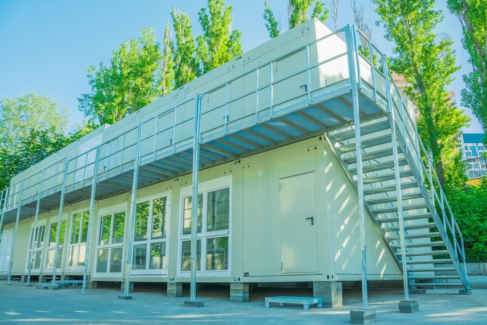 A Large White Building With Stairs Leading Up to the Second Floor — Cutting Edge Painting Contractors QLD in The Dawn, QLD