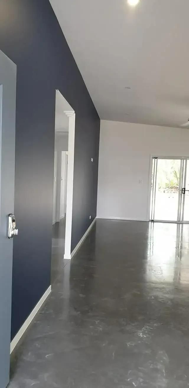 A Large Empty Room With a Concrete Floor and Blue Walls — Cutting Edge Painting Contractors QLD in The Dawn, QLD