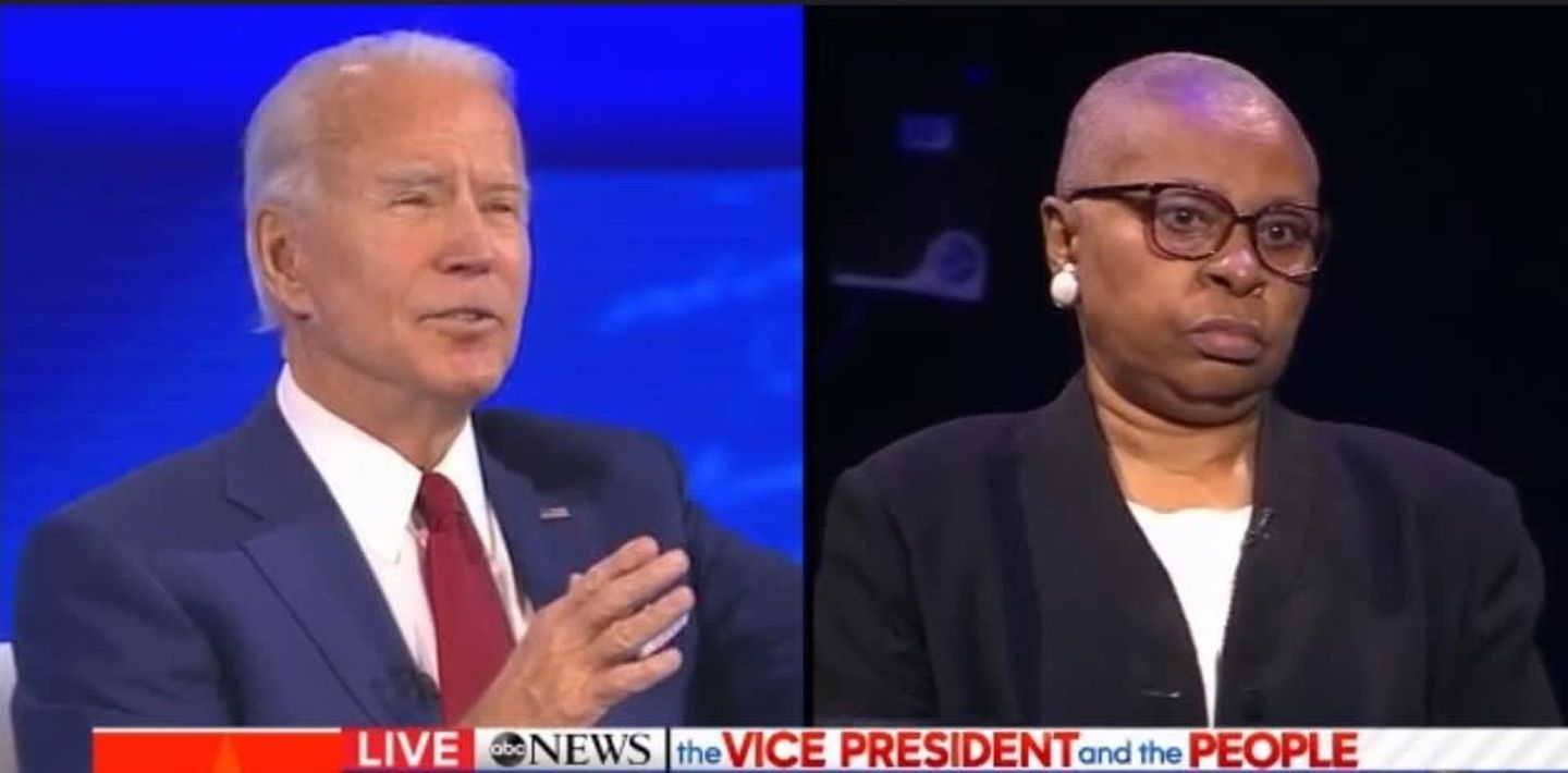 Joe Biden and a woman with glasses during a television interview.