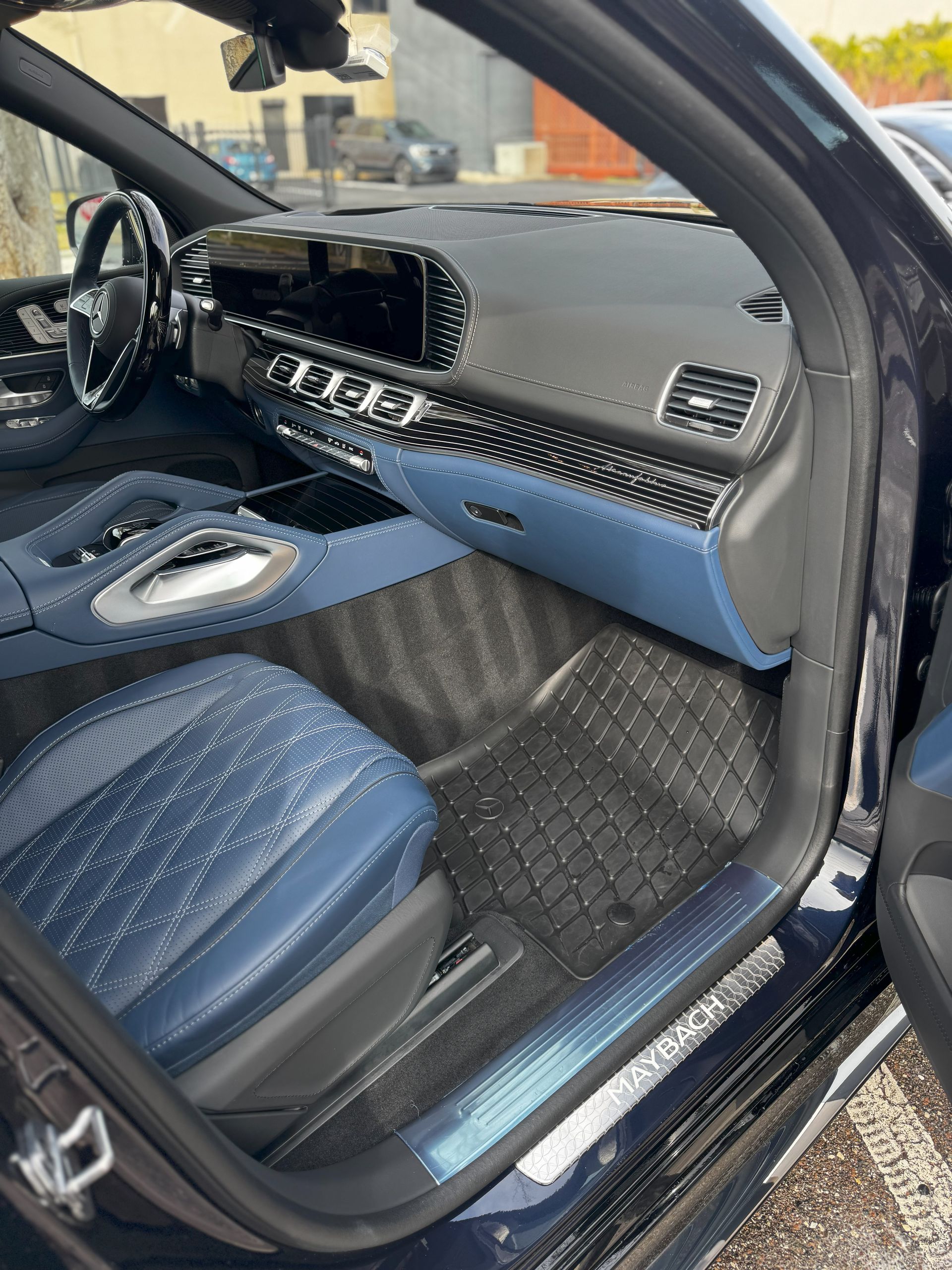 Blue car interior: passenger seat, dashboard, floor mats, and door trim, all in blue and black with silver accents.