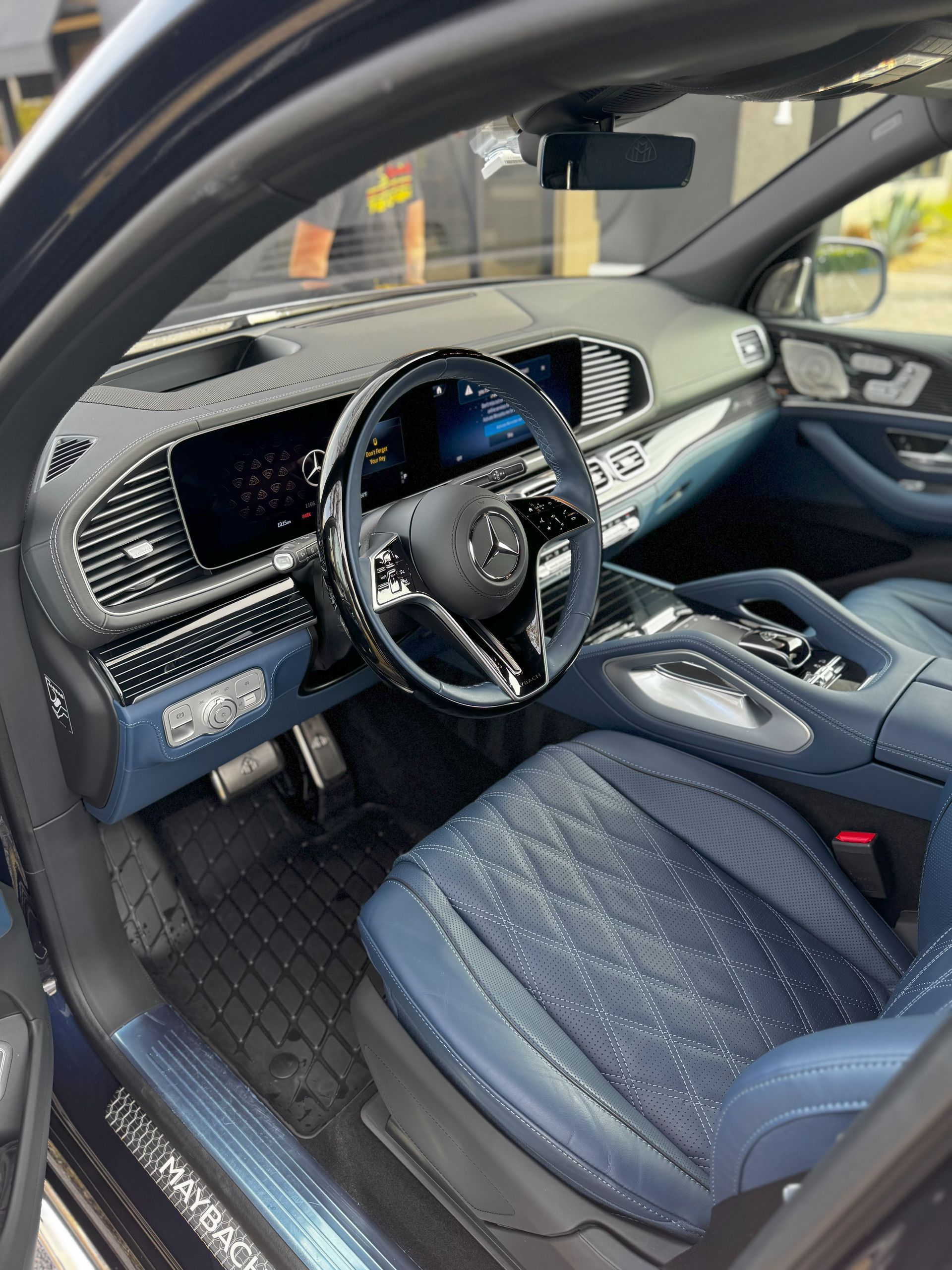 Blue leather interior of a Mercedes-Benz SUV, showcasing the dashboard, steering wheel, and driver's seat.