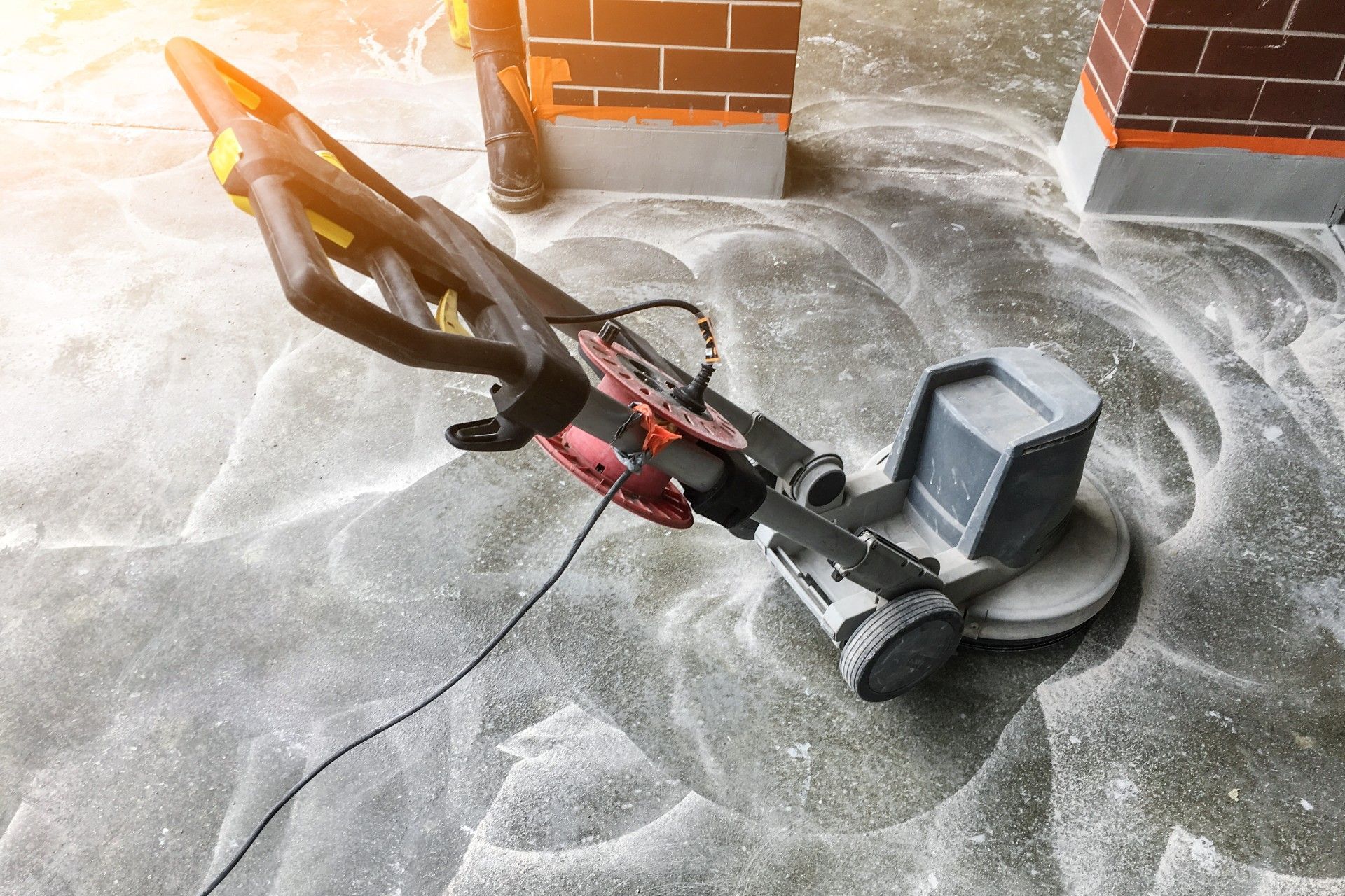 A vacuum cleaner is sitting on a concrete floor.