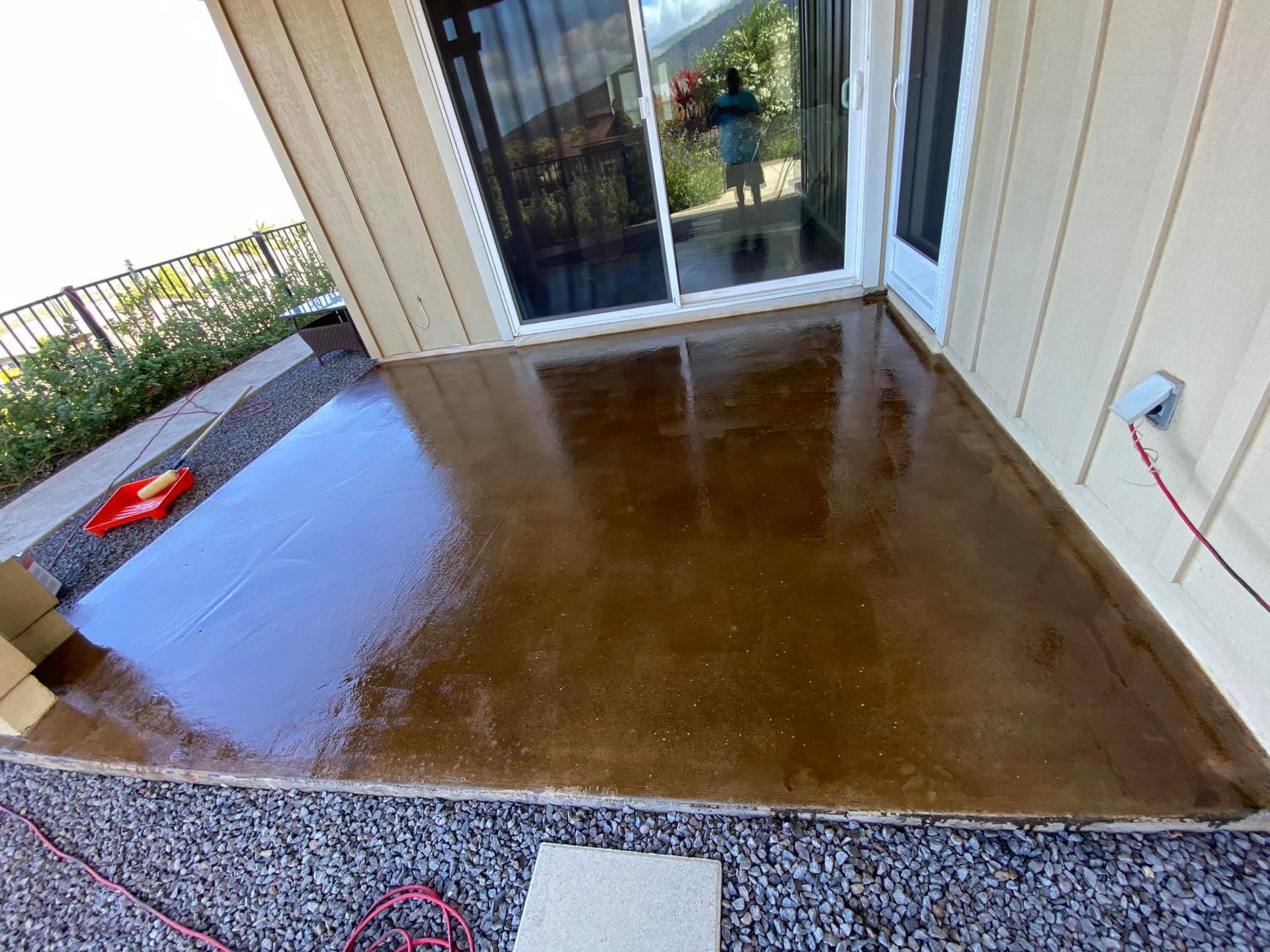 A patio with a sliding glass door and a concrete floor.