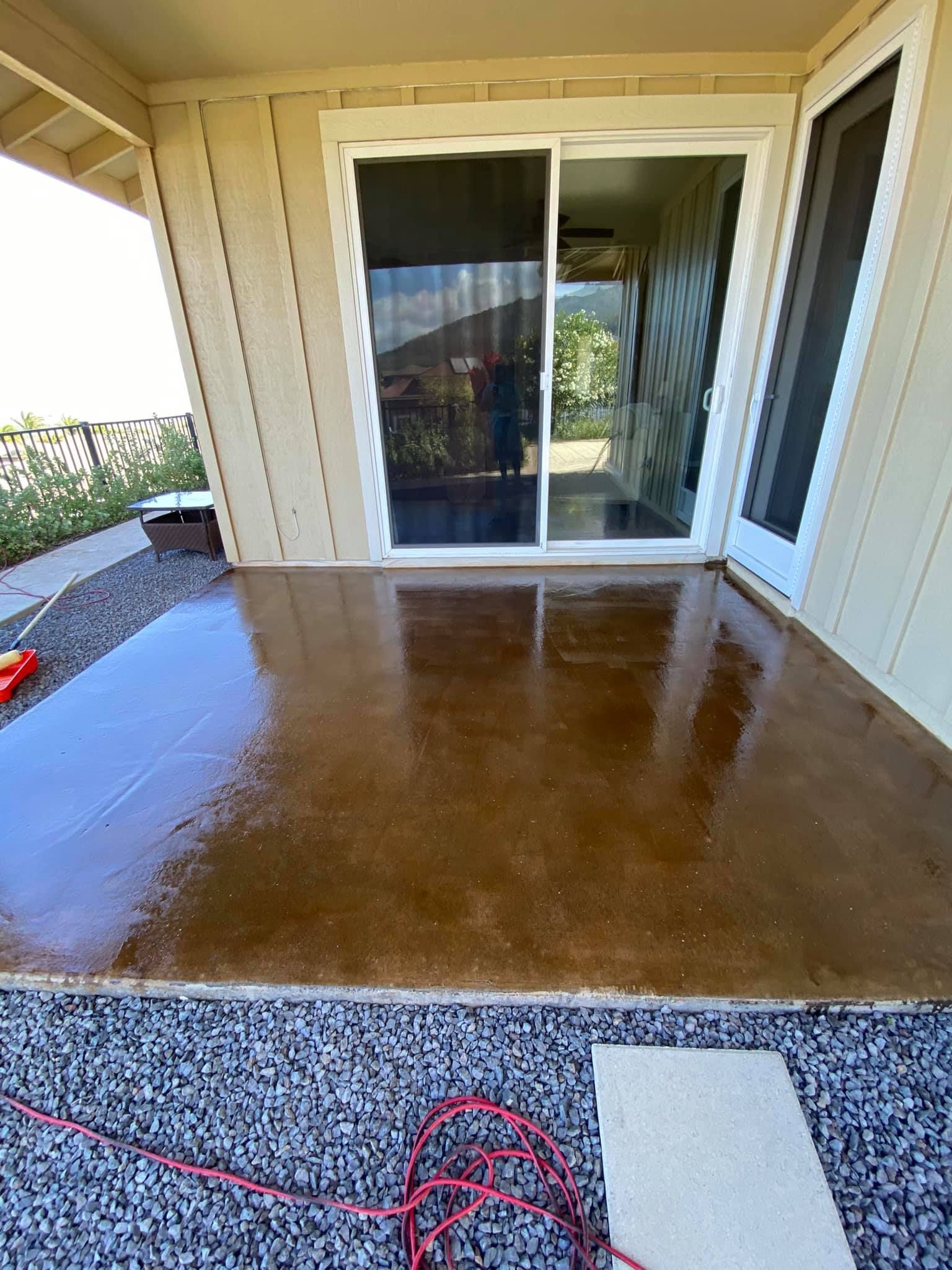 A patio with a sliding glass door and a concrete floor.