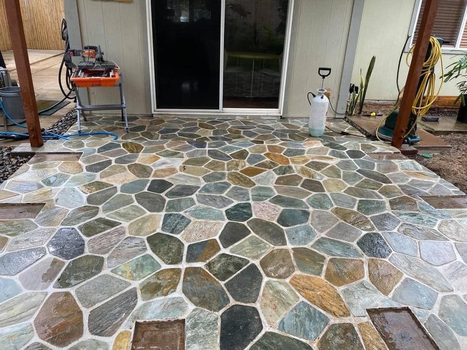 A patio with a sliding glass door and a propane tank.