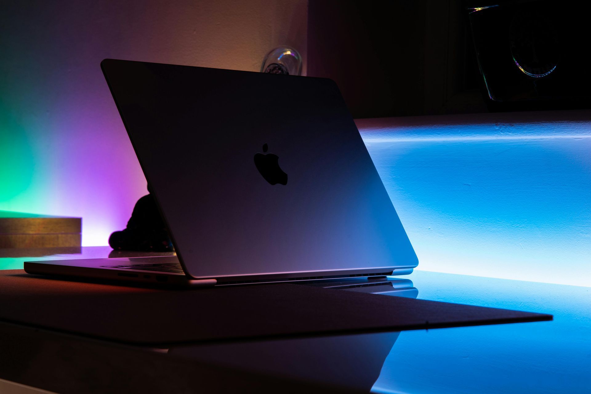 Open laptop on a desk with blue and purple LED lighting